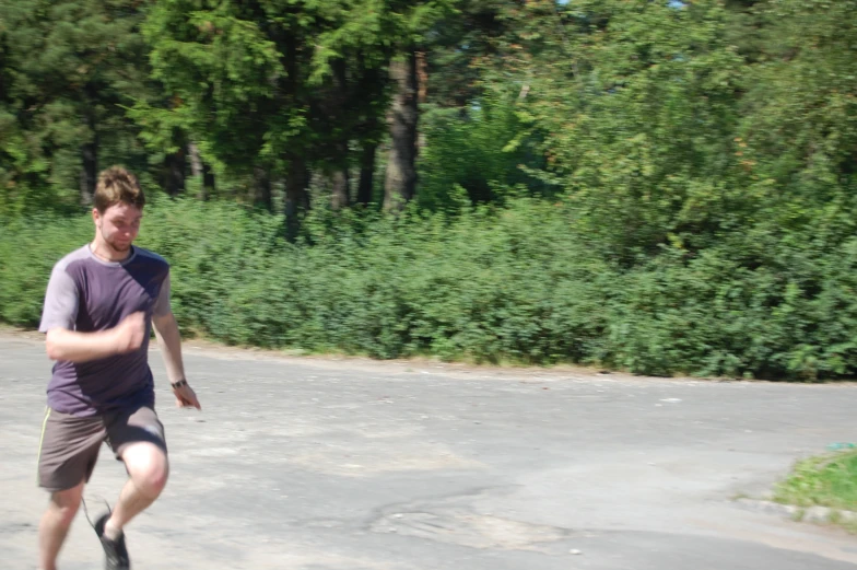 a young man in shorts is skating on a gravel surface