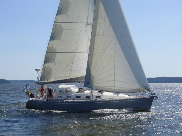 a small white sailboat in the ocean