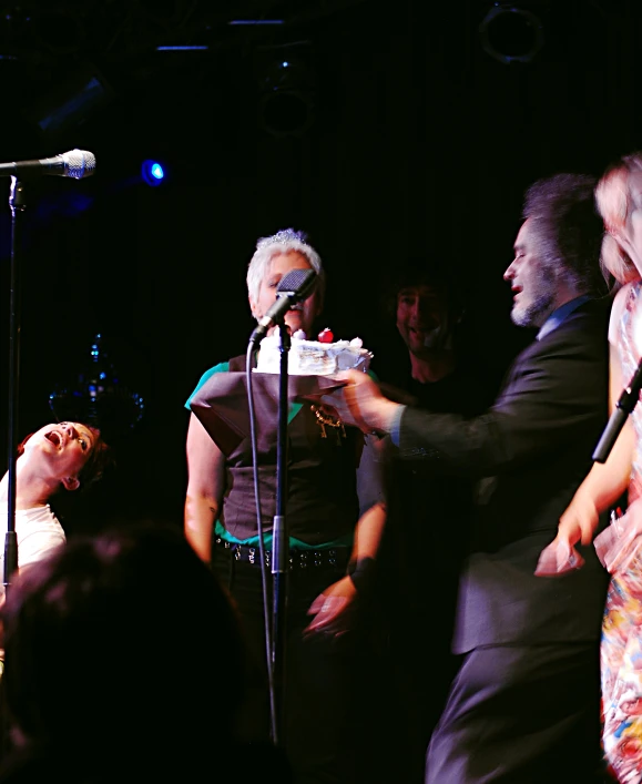 a woman with white hair is holding a microphone