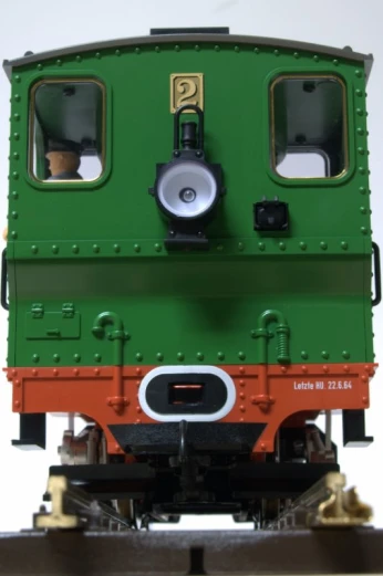 a small green train car sitting on the tracks