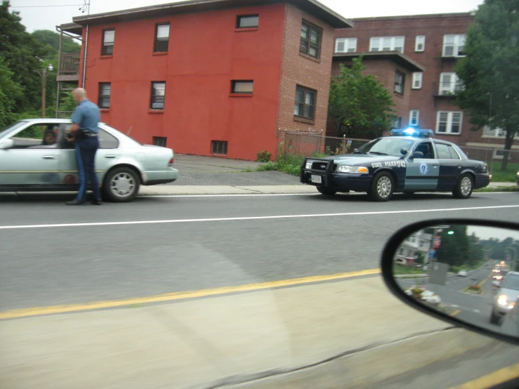 a police car next to another car parked on the side of a road