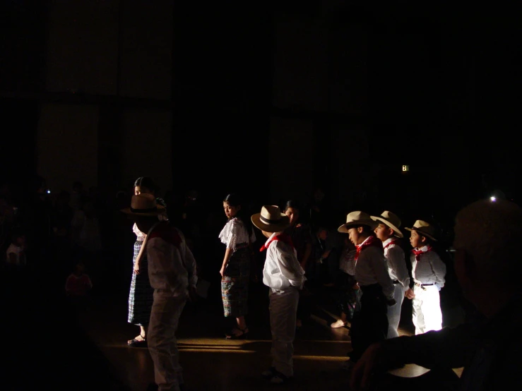 group of people wearing hats standing in the dark