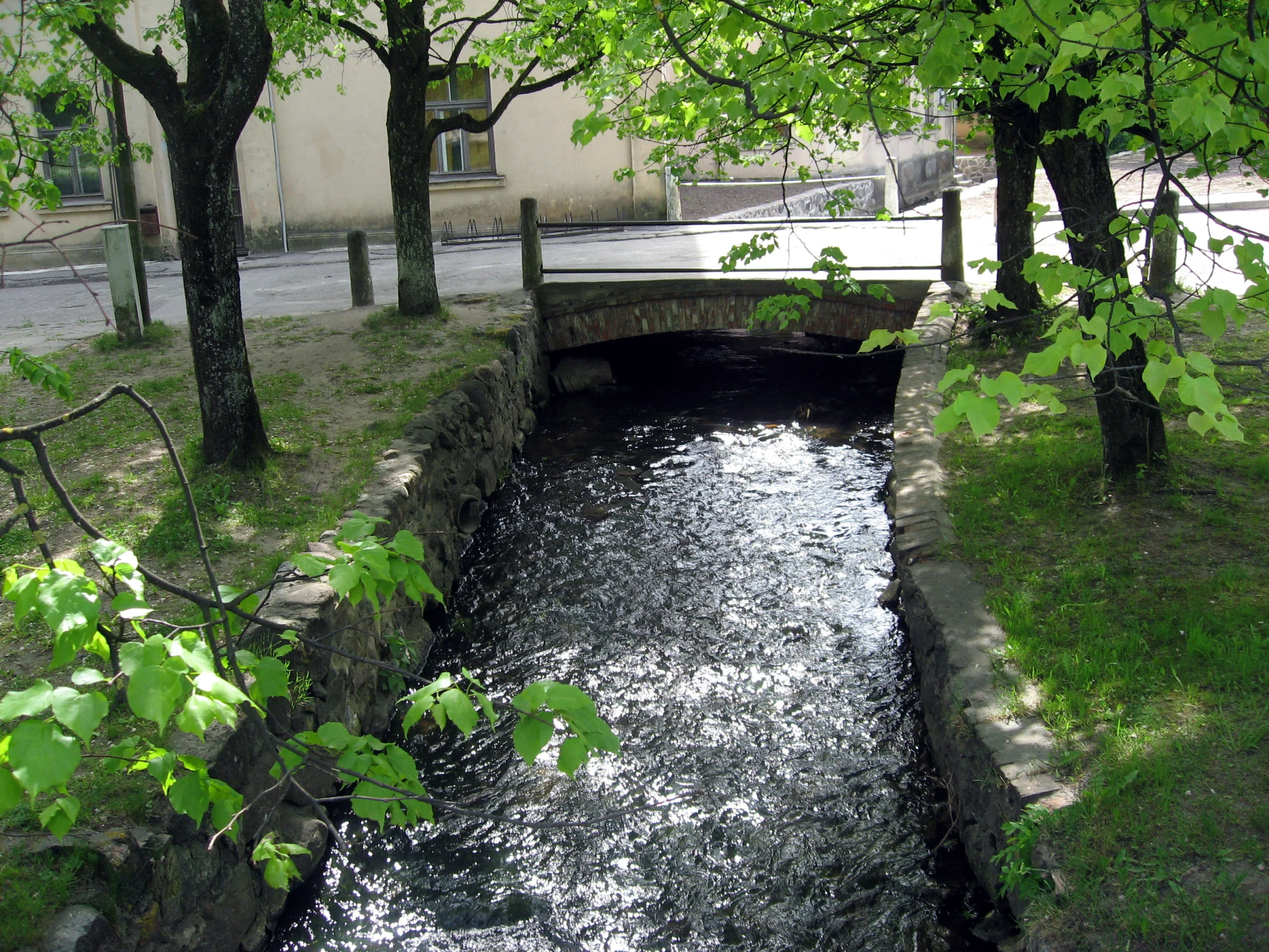 there is a small water channel flowing into the middle of the street