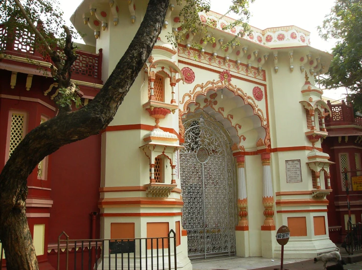 a tree in front of a building with an archway