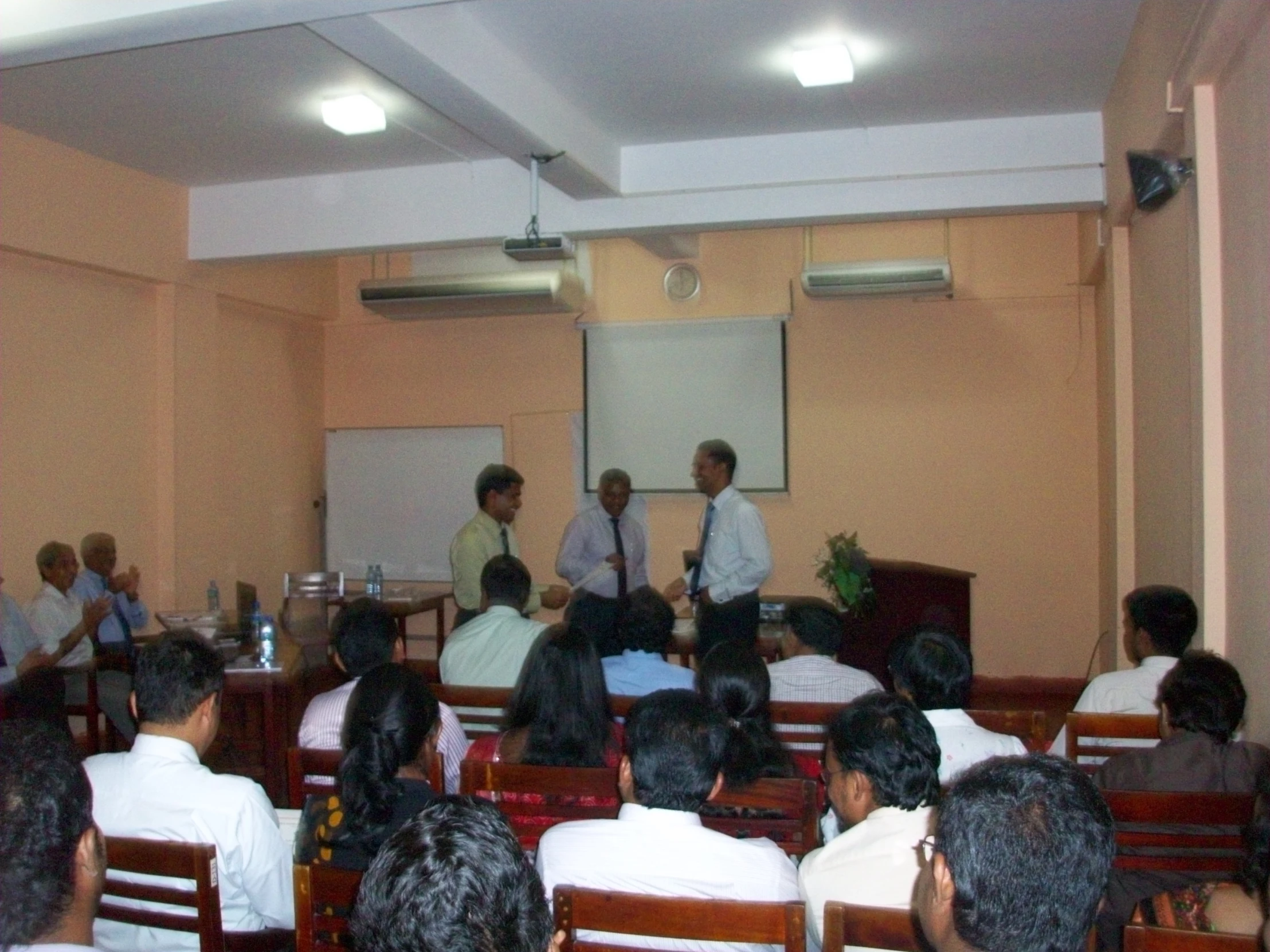 men standing behind their heads at a business presentation