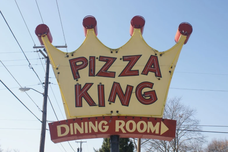 a large yellow sign advertising pizza king dining room