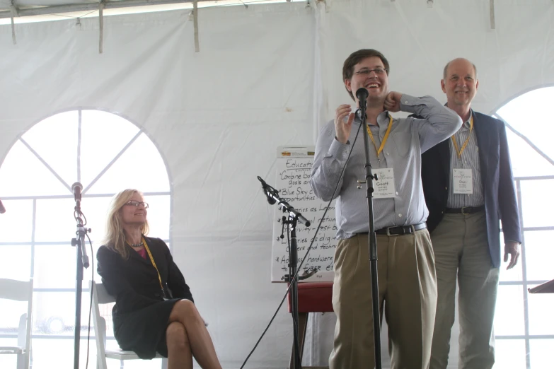 a man and two women standing in front of microphones