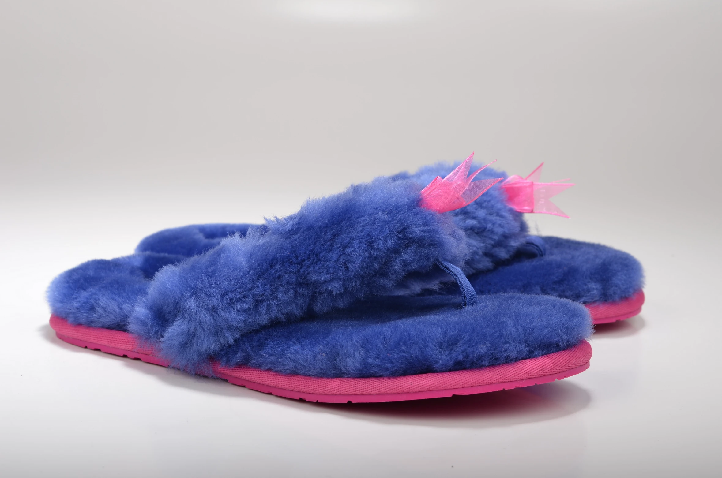 a pair of blue slippers with pink soles on top of them