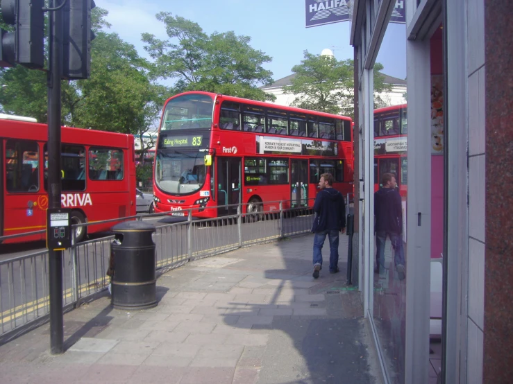 two red double decker buses parked in front of a building