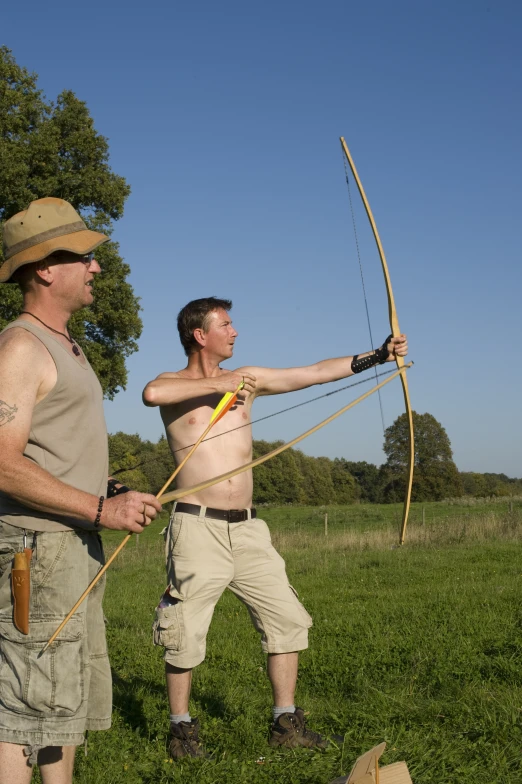 two men hold up their bows and arrow