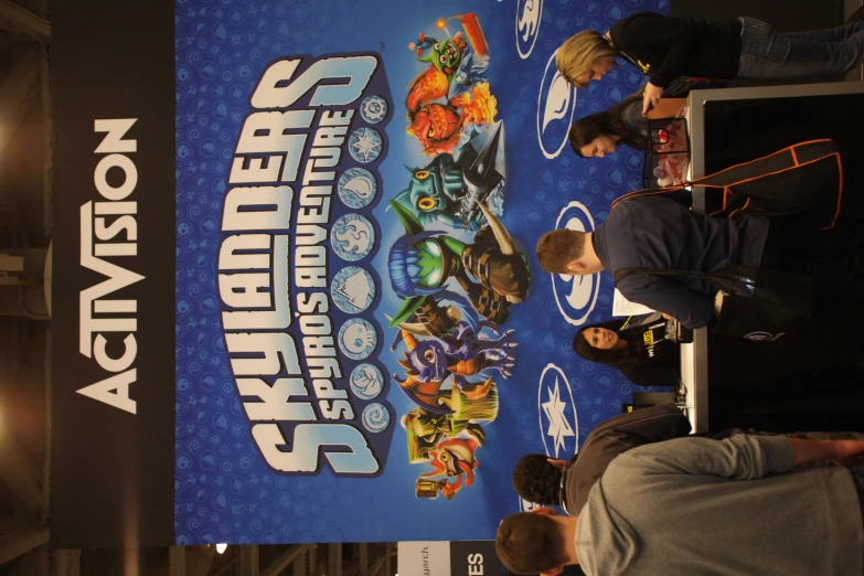 a group of people standing around a table on top of a convention poster