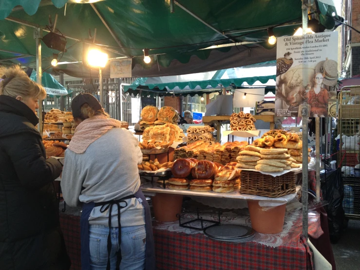 the people are buying bread from the stand