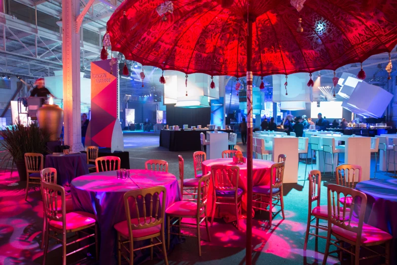 bright red and blue lighting shine on pink umbrellas