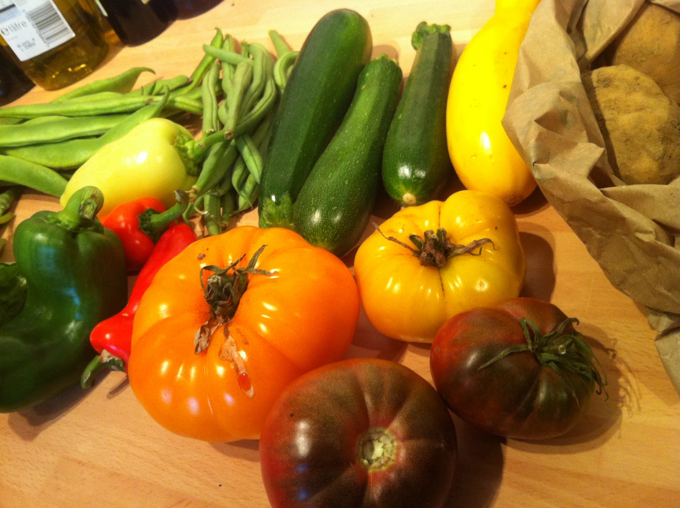 tomatoes, cucumbers, peppers and green beans are on a table