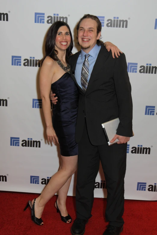a woman posing with her arm around a man