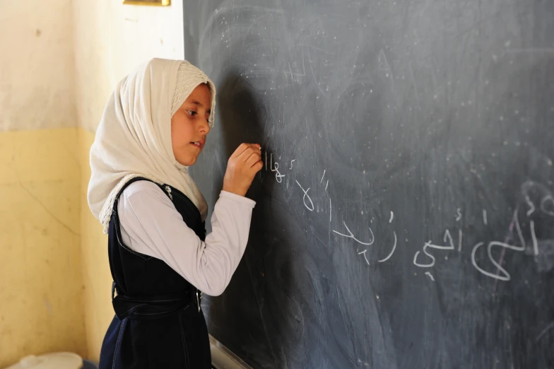 a woman is writing on a blackboard