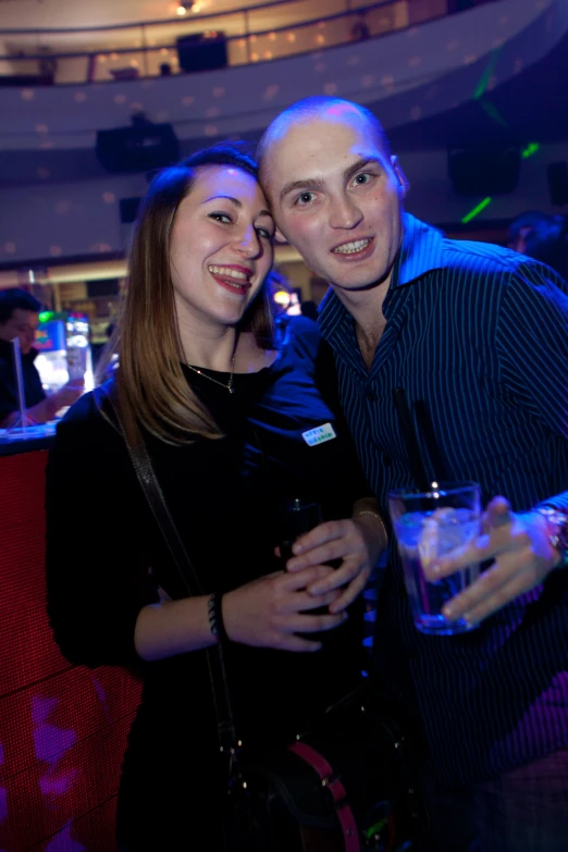 a man and woman standing next to each other in front of a crowd