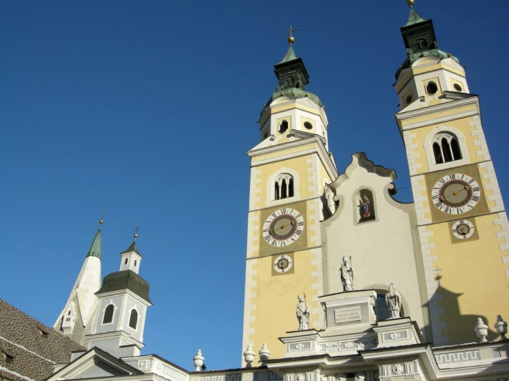 two towers with clock on them are in the sky