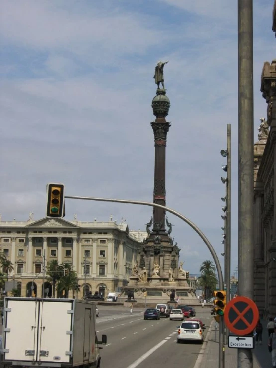 traffic on a city street with a traffic light and large building