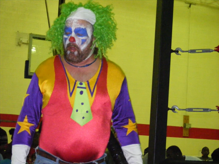 a clown with a tie and his wig is posing for the camera