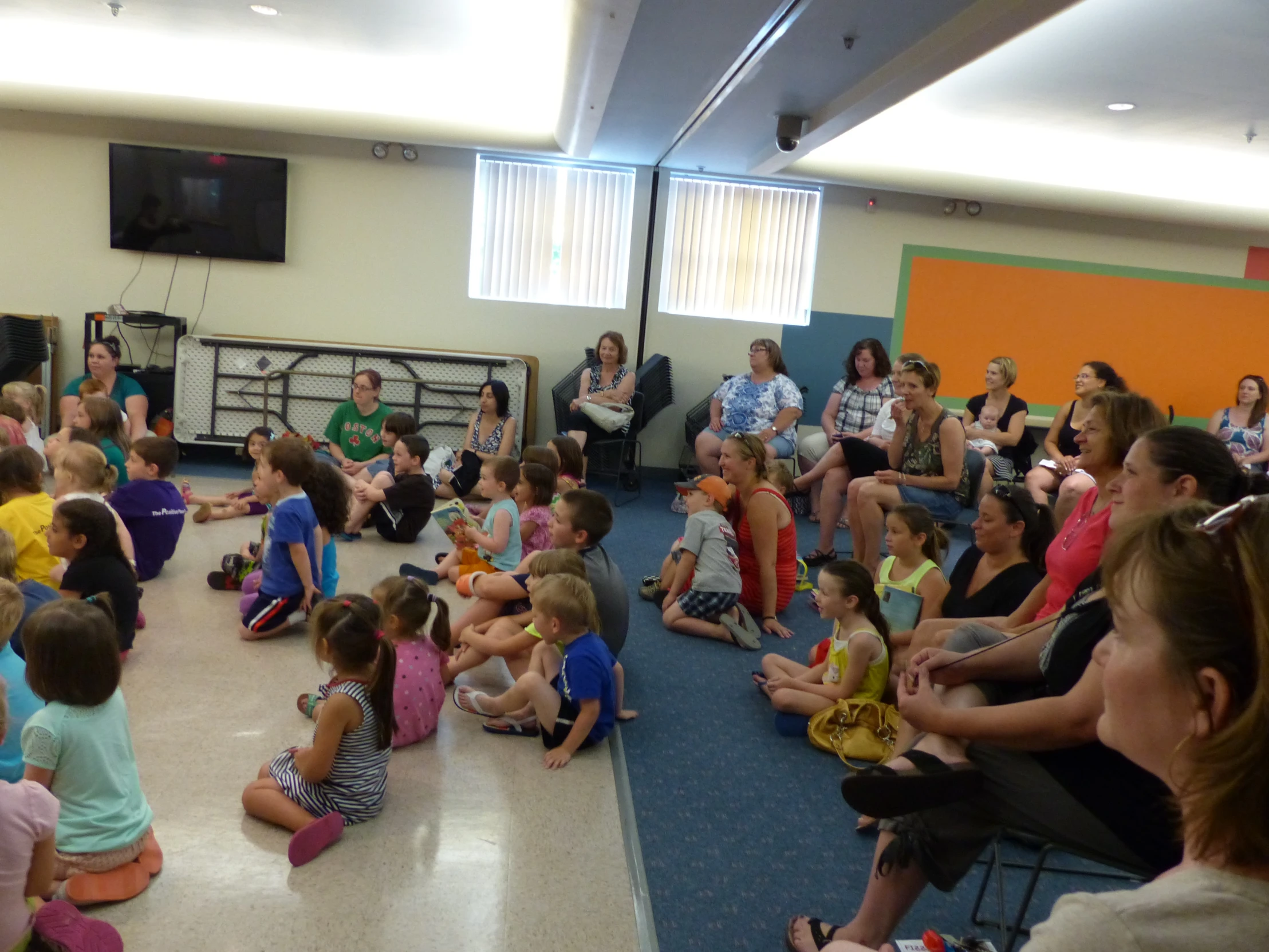 a group of children sit in a circle with adults