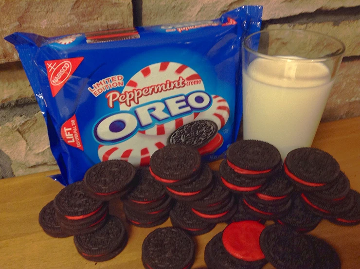 cookies, cream and a package of oreo are sitting next to a milk glass