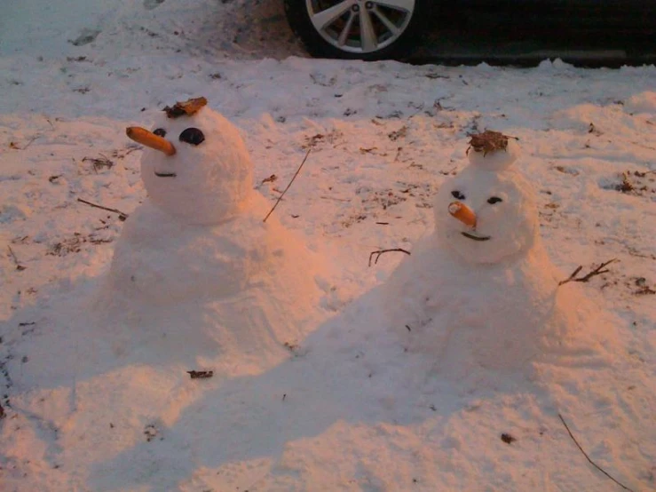 there are two snowmen that are sitting in the snow