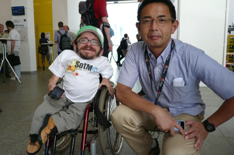 two people posing for a po, one is in a wheelchair