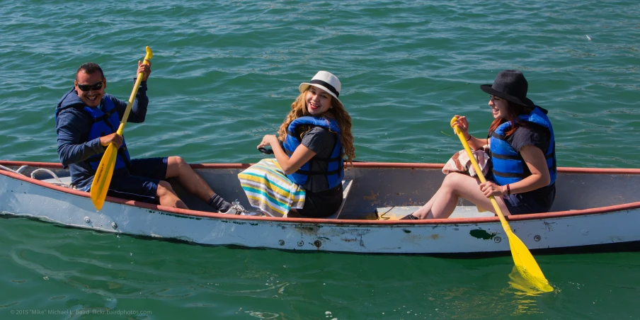 a group of people paddling a small boat on the water