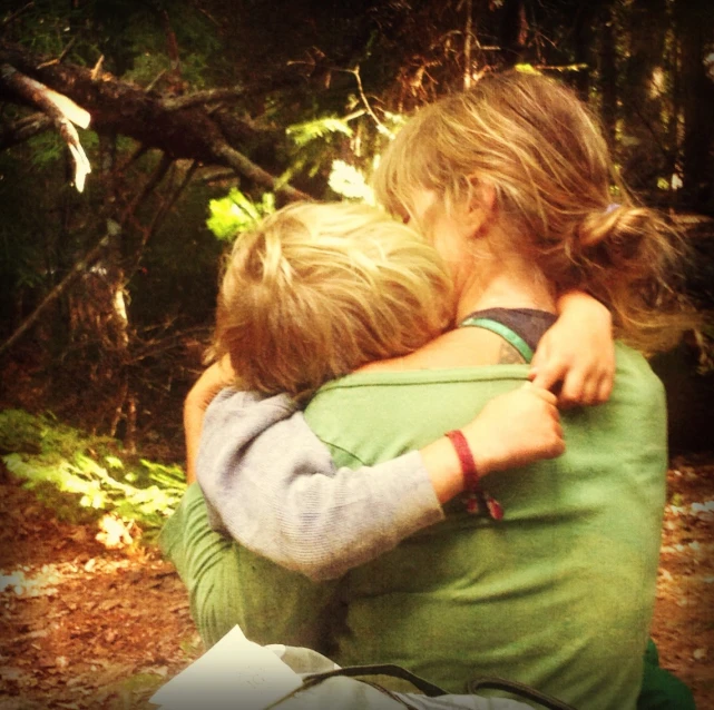 two girls hug each other in a park