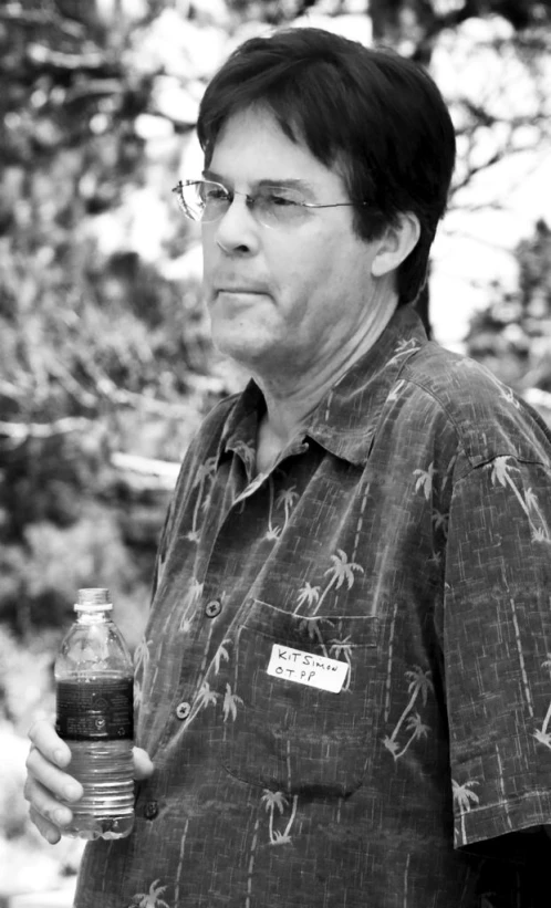 a man with glasses holds a bottle of water