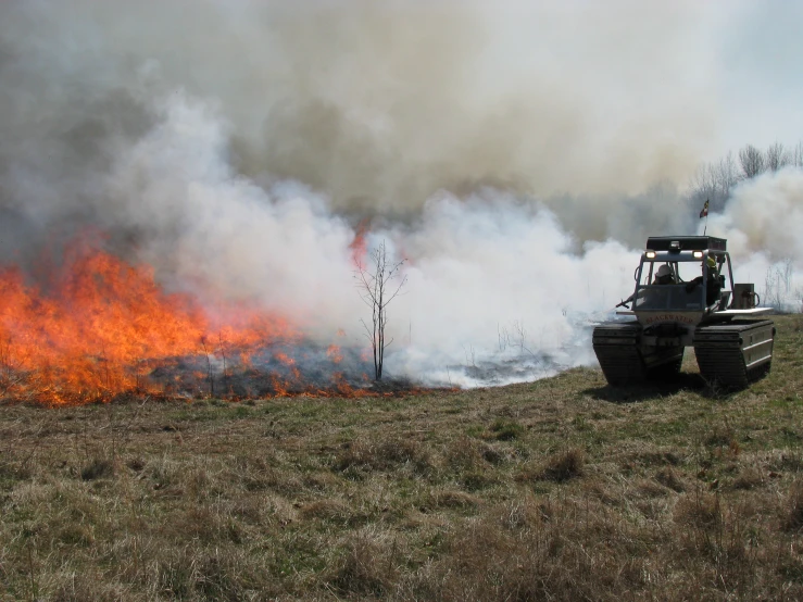 the tractor is near to the large fire