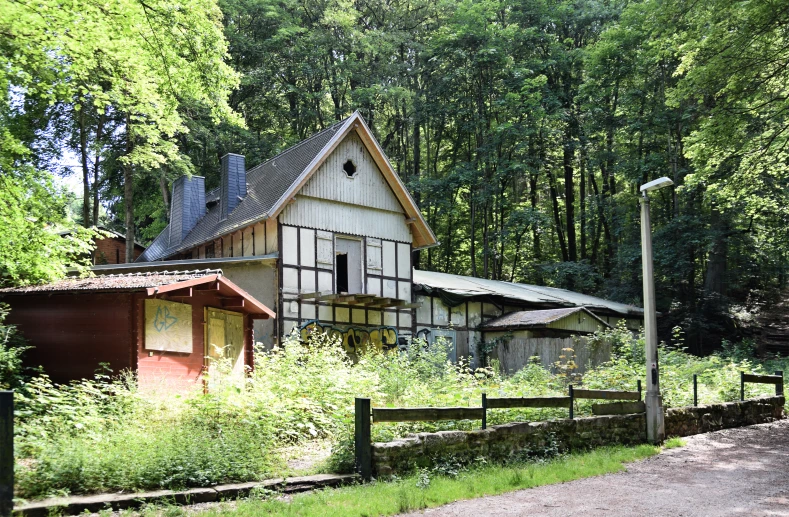 an old building sitting behind a fence surrounded by trees