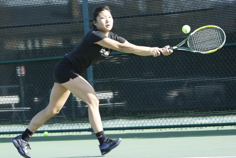 a female tennis player running to hit the ball