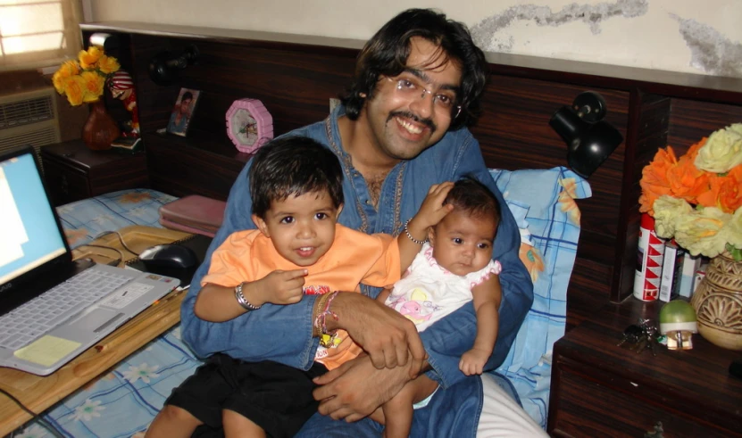 a man and two children sitting in a chair