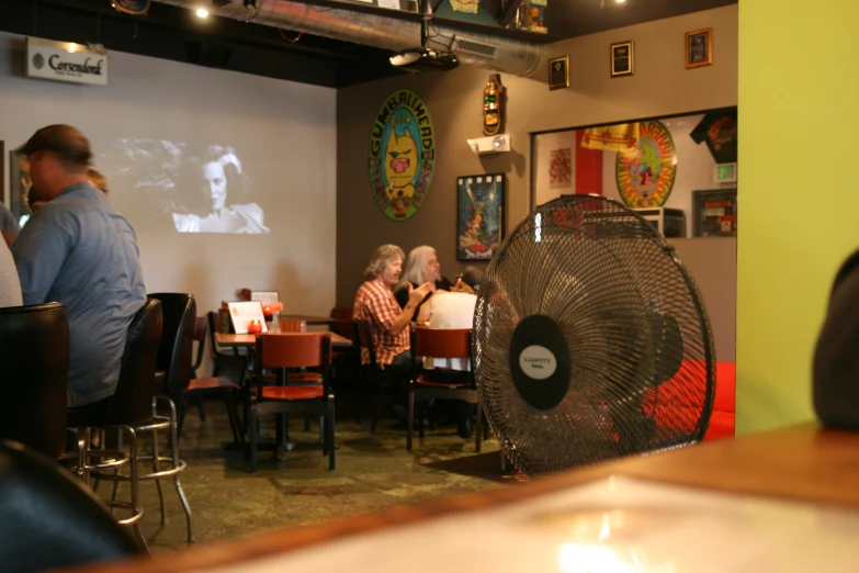 people sitting in a small restaurant eating a meal