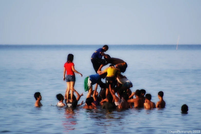 a group of people standing and riding on top of a raft in the ocean