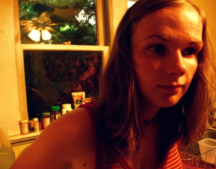 woman with piercings looking at camera in front of window