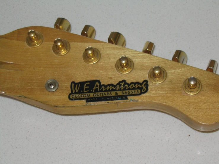 a wooden guitar neck with several gold s on it