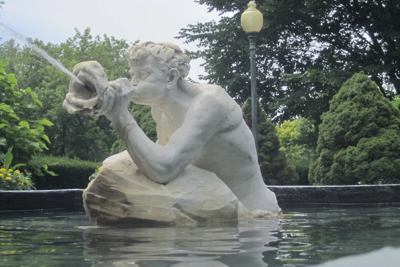 statue with hands holding large fish in large water