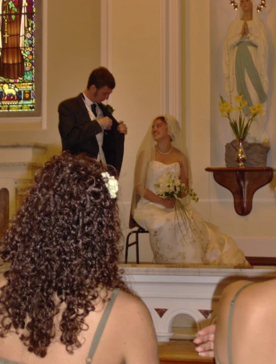 the groom places his bride's veil on her head
