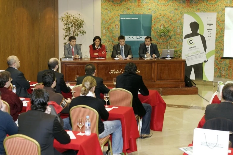 people sitting at tables during a meeting on their laptop computers