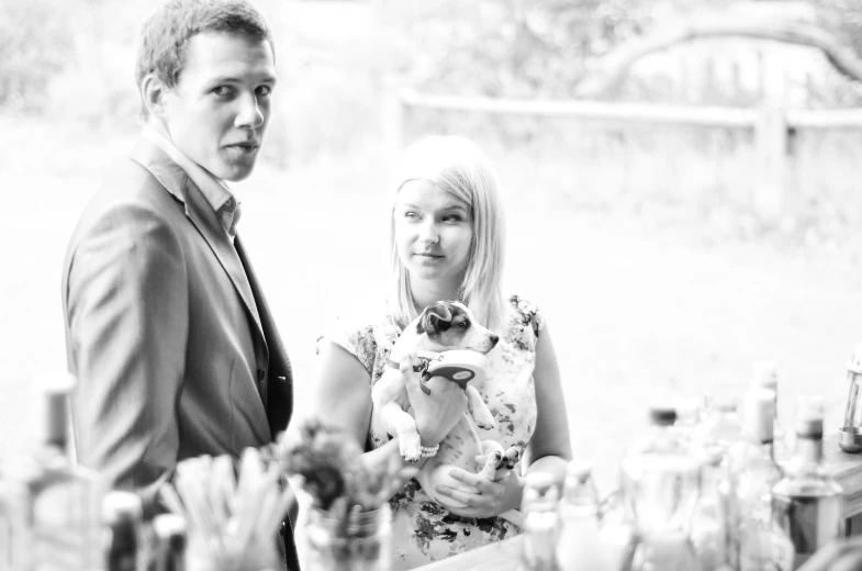 a young man standing next to a woman in front of bottles