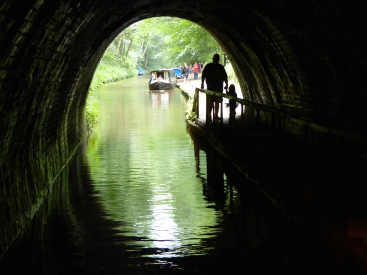 people on a boat riding into a tunnel