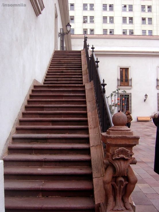 a woman looks down the stairs on her cell phone