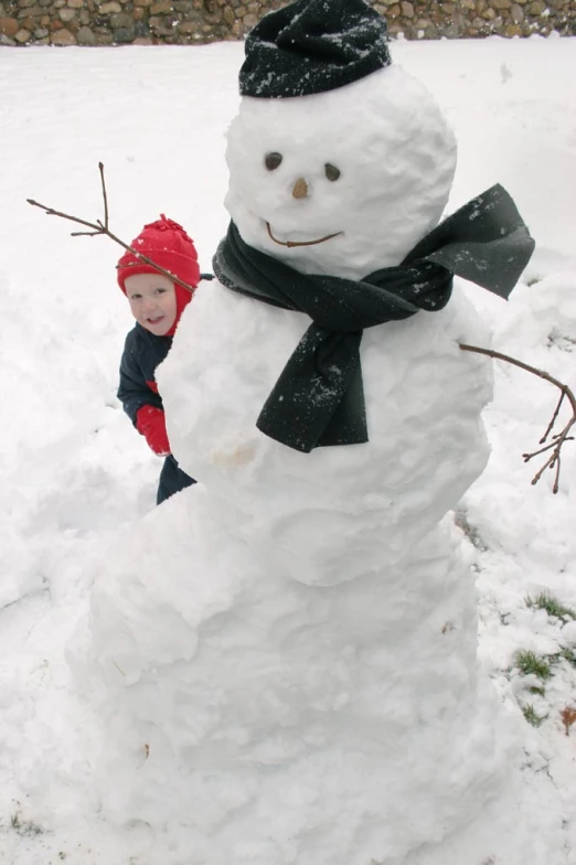 a little boy next to a snow man