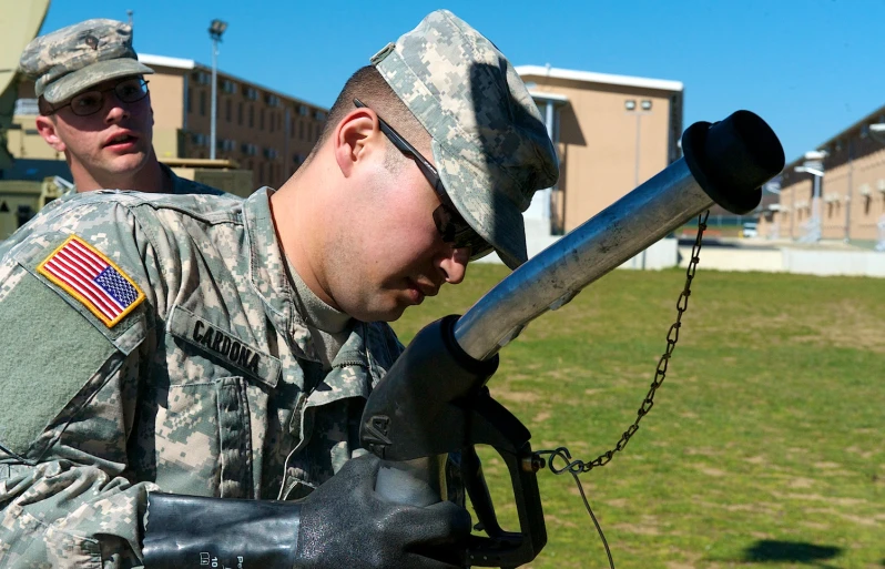 a soldier wearing uniform leaning on a metal handrail