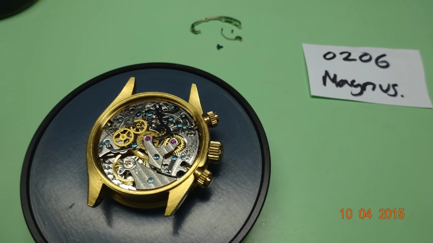 a small gold clock on a black shelf