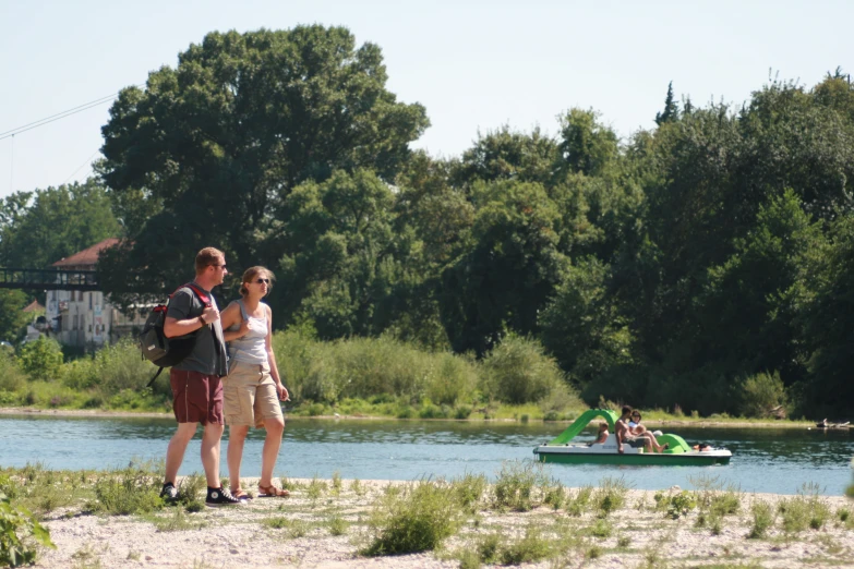 two people standing at the edge of a river