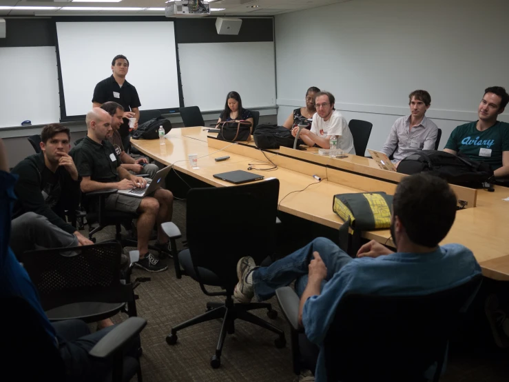 a group of people sitting around a conference room table